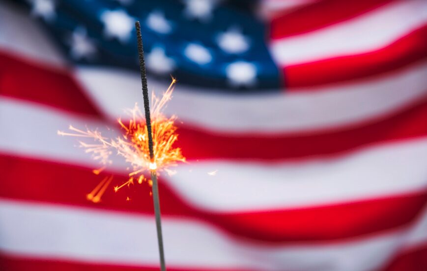 American flag behind a sparkling stick