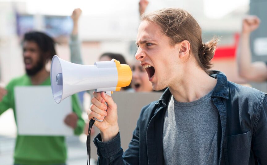 A young man talking to a megaphone, protecting his freedom of speech