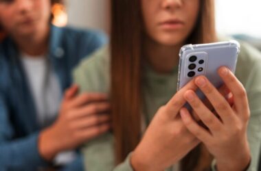 A sad girl looking at her phone being cyberbullied