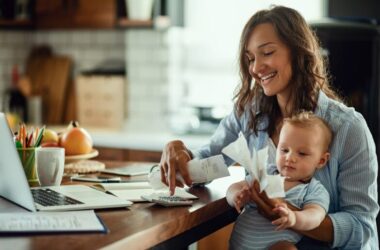 Young mother holding a baby and calculating the cost of raising a child