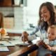 Young mother holding a baby and calculating the cost of raising a child