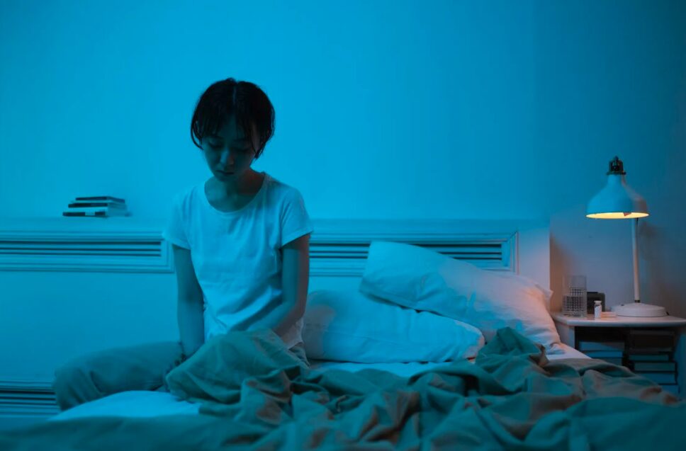 A young woman living as hikikomori, sitting on her bed