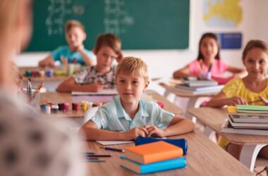 A classroom with children listening to the teacher