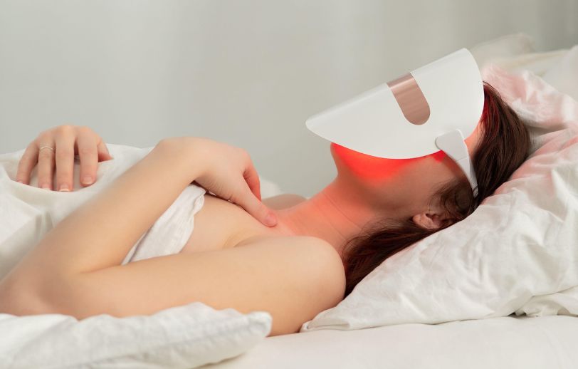 Woman with a red light therapy mask on her face