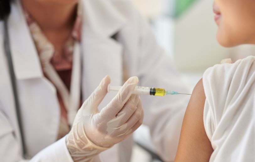 A close up of a girl getting a vaccination shot.