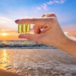 Hand holding vitamin D at the beach