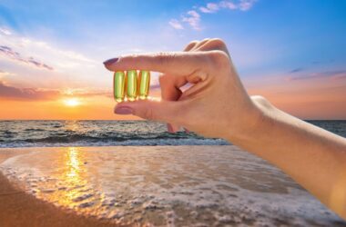 Hand holding vitamin D at the beach