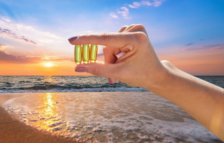 Hand holding vitamin D at the beach