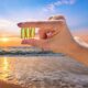 Hand holding vitamin D at the beach